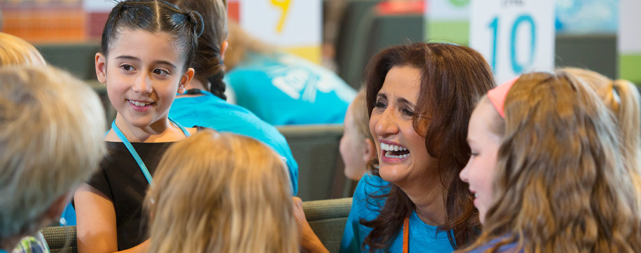 A female volunteer smiles during VBS.