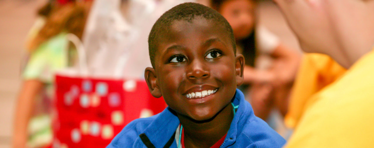 A preteen boy smiles brightly at his small group leader.