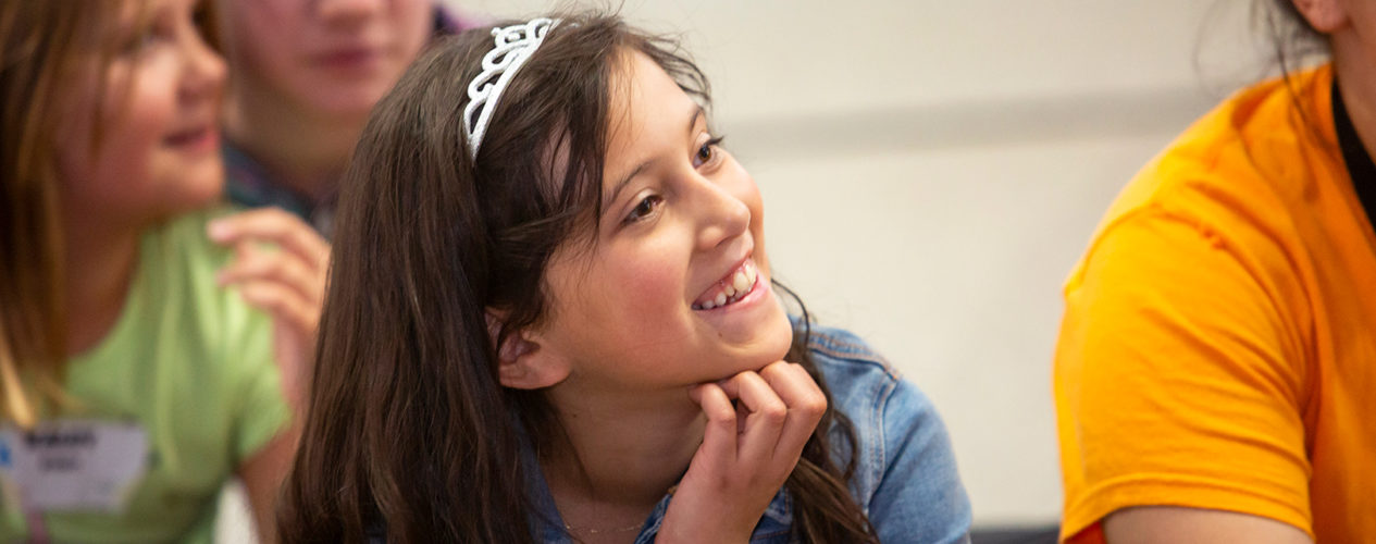 A preteen girl smiling during small group time.