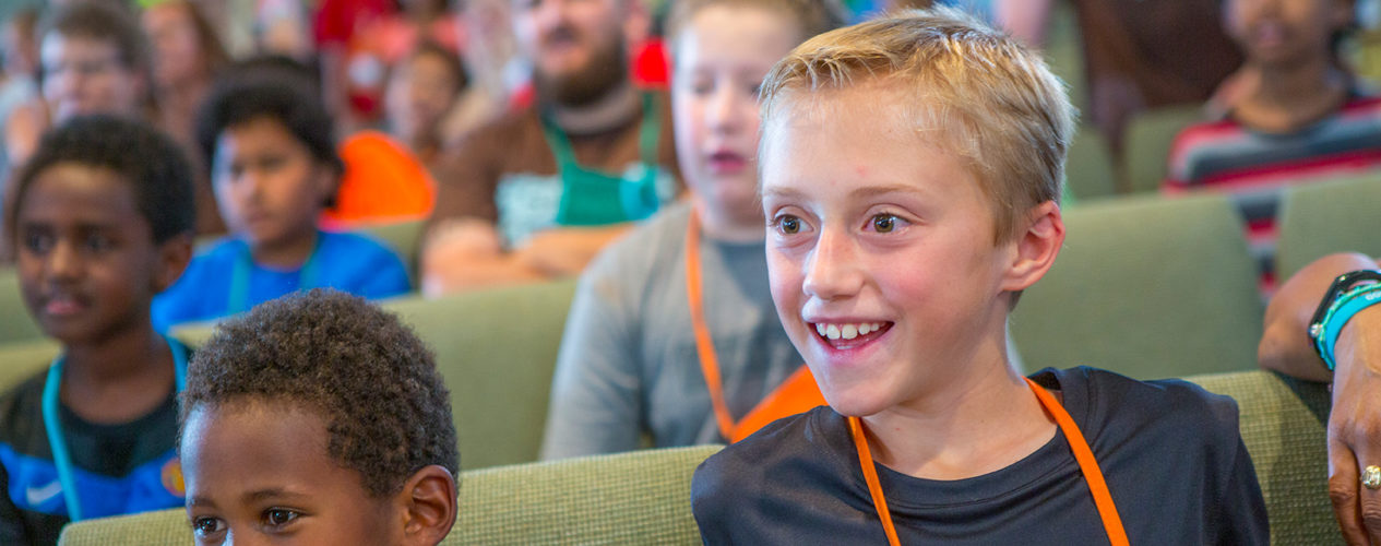 An elementary-aged boy excitedly participates in a president's day message.
