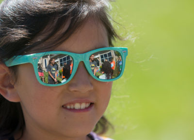 A girl in sunglasses participates in an Earth Day party.