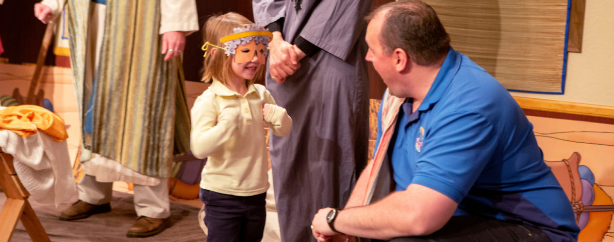 A dad encourages his daughter as she participates in a Christmas play.