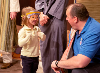 A dad encourages his daughter as she participates in a Christmas play.