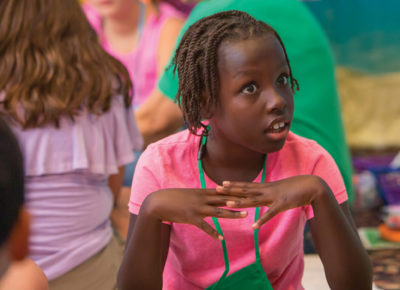 A elementary girl looks shocked during a lesson about the woman at the well.