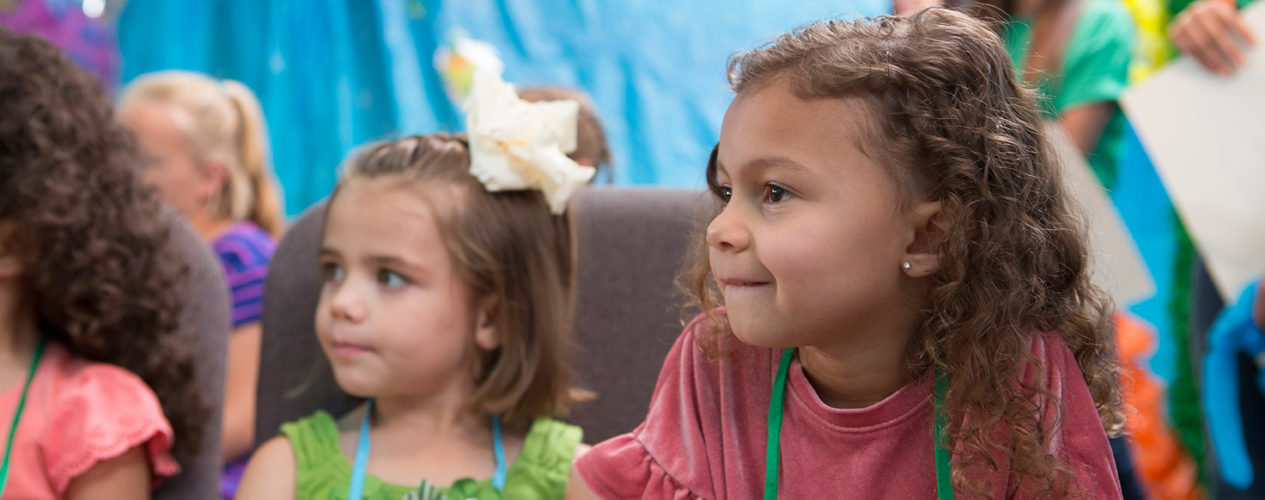 A preschool girl listens during a lesson on Zacchaeus.