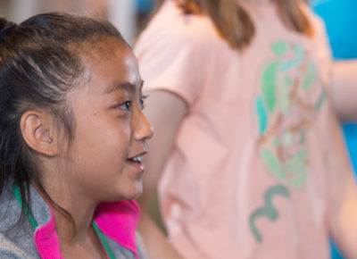 A preteen girl smiles during an activity.