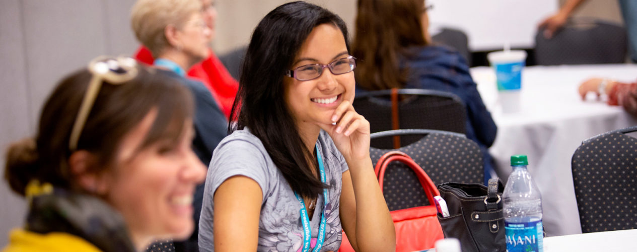 An intern smiles while sitting at a table from training.