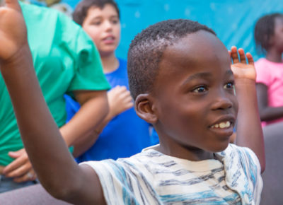 An elementary-aged boy excitedly participates in the Fruit of the Spirit lesson.