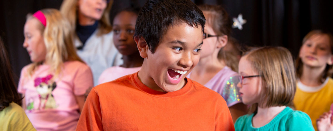 Preteen boy is crazy excited as his classmates are behind him.