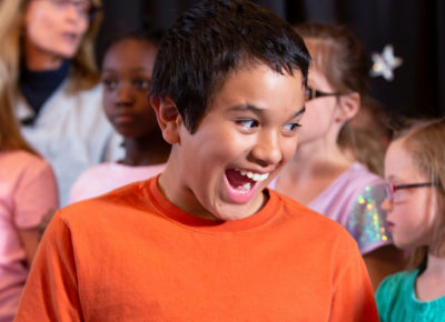 Preteen boy is crazy excited as his classmates are behind him.