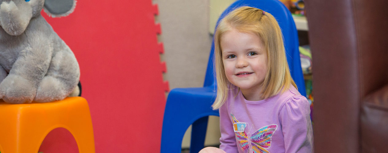 A preschool girl smiles during a lesson on Mary ad Martha.