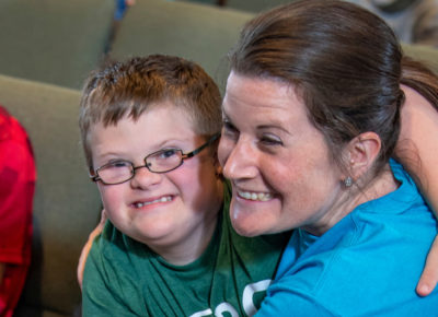 A VBS volunteer hugging a boy with special needs.