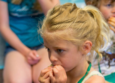 A girl eating a Thanksgiving Turkey cookie.