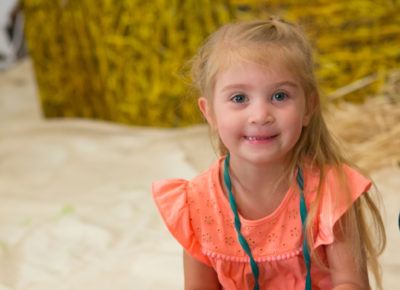 A preschool girl smiles during a lesson on the church.