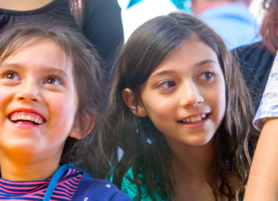 Two elementary girls are smiling as they participate in an Easter idea..