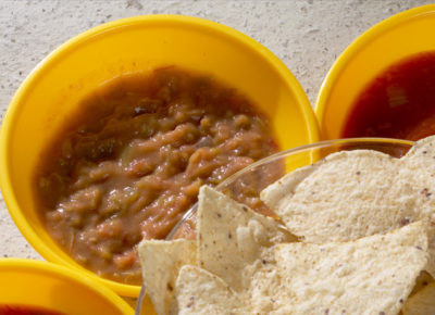 A bowl of chips surrounded by three smaller bowls of salsa and beans. This snack accompanies a preteen message and snack about being the salt of the earth.