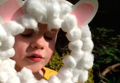 a preschool age boy wearing a lamb mask craft he made in Sunday school