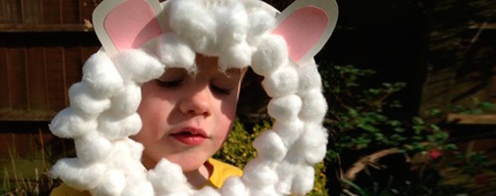 a preschool age boy wearing a lamb mask craft he made in Sunday school
