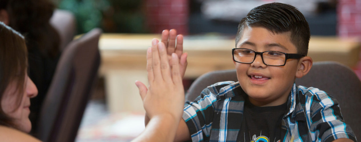 A mom gives her son a high five after they complete a holiday service project.
