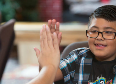 A mom gives her son a high five after they complete a holiday service project.