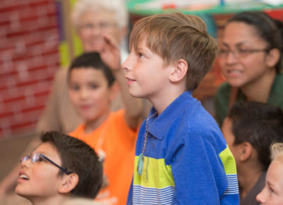 An elementary aged boy eagerly listens to the story of Jesus calming the storm.