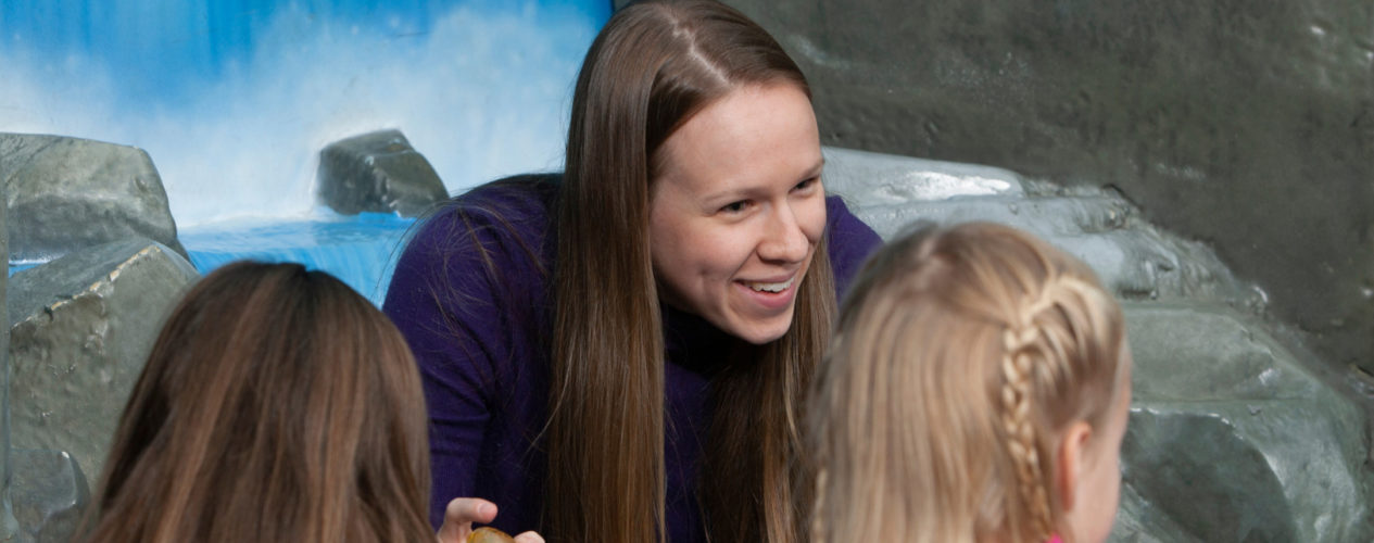 A female children's ministry volunteer is leading a small group of children.