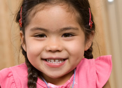 A preschool girl smiles at her independence.