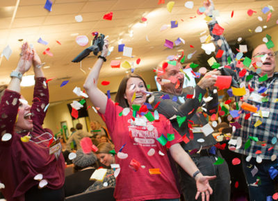 A children's ministry publicity team that is throwing large pieces of confetti in the air.