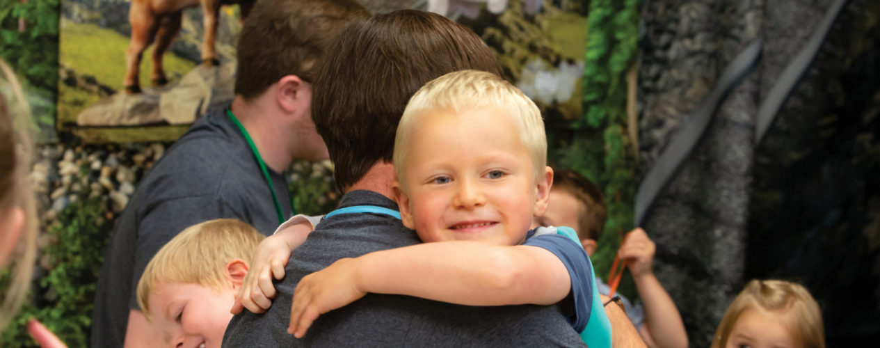 A child with special needs is hugging his crew leader at VBS.