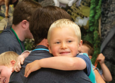 A child with special needs is hugging his crew leader at VBS.