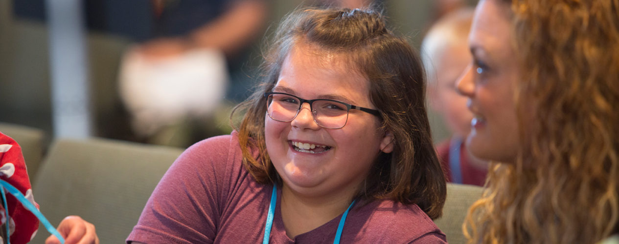 A preteen girl smiles during her preteen small group she just transitioned to.