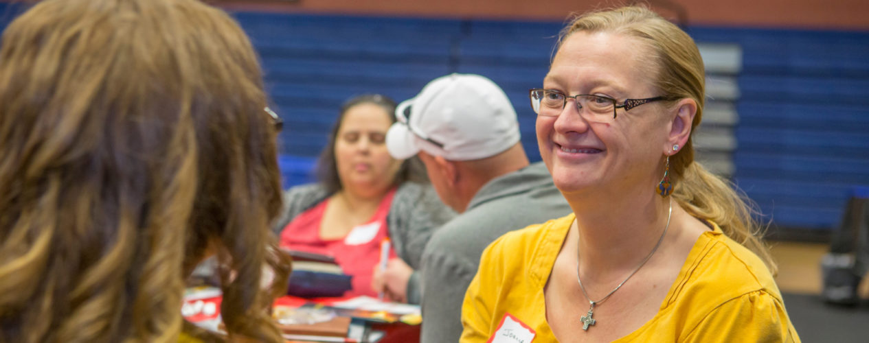 A female volunteer smiles at a volunteer recruiting event.