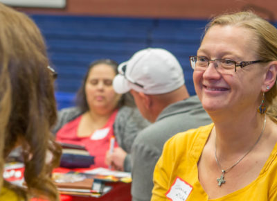 A female volunteer smiles at a volunteer recruiting event.