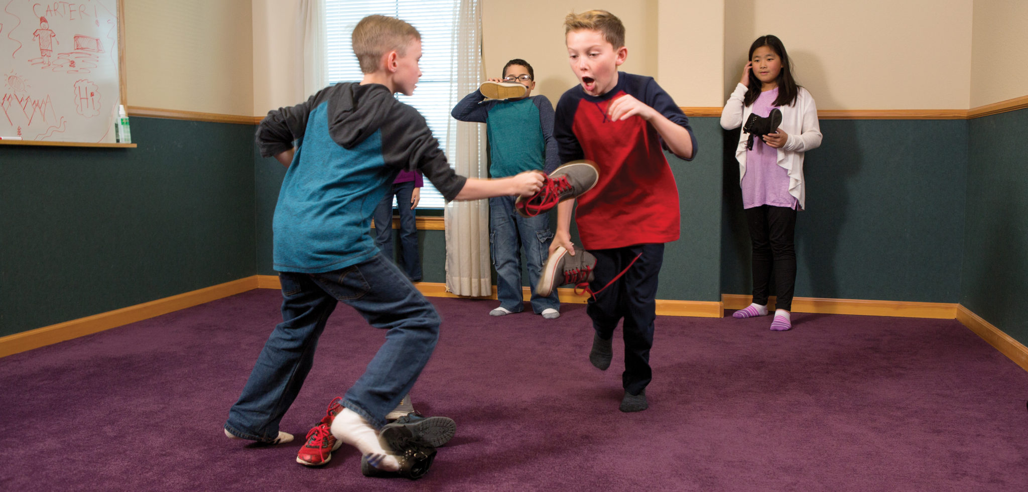 A group of children playing an indoor game involving their shoes.
