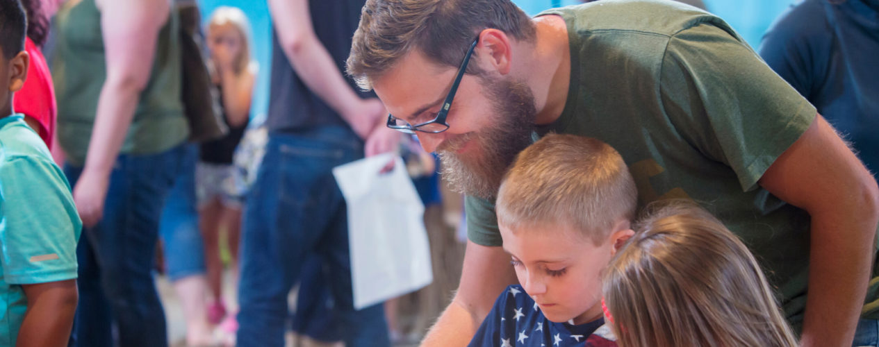 A father and a son participate in a family ministry activity.