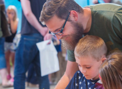 A father and a son participate in a family ministry activity.