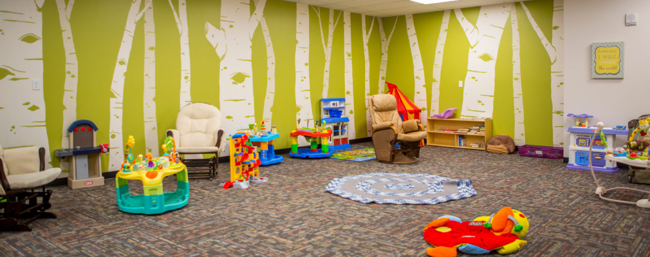 An empty church nursery that is clean and organized. It has a lot of nursery toys.