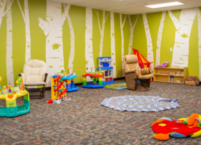 An empty church nursery that is clean and organized. It has a lot of nursery toys.