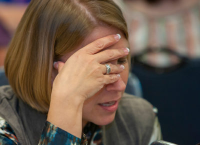 A female volunteer puts her hand on her face in frustration.