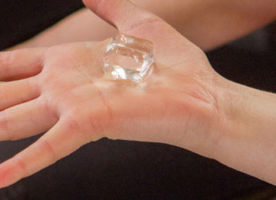 A child holding an ice cube during an Easter message on Jesus' suffering.