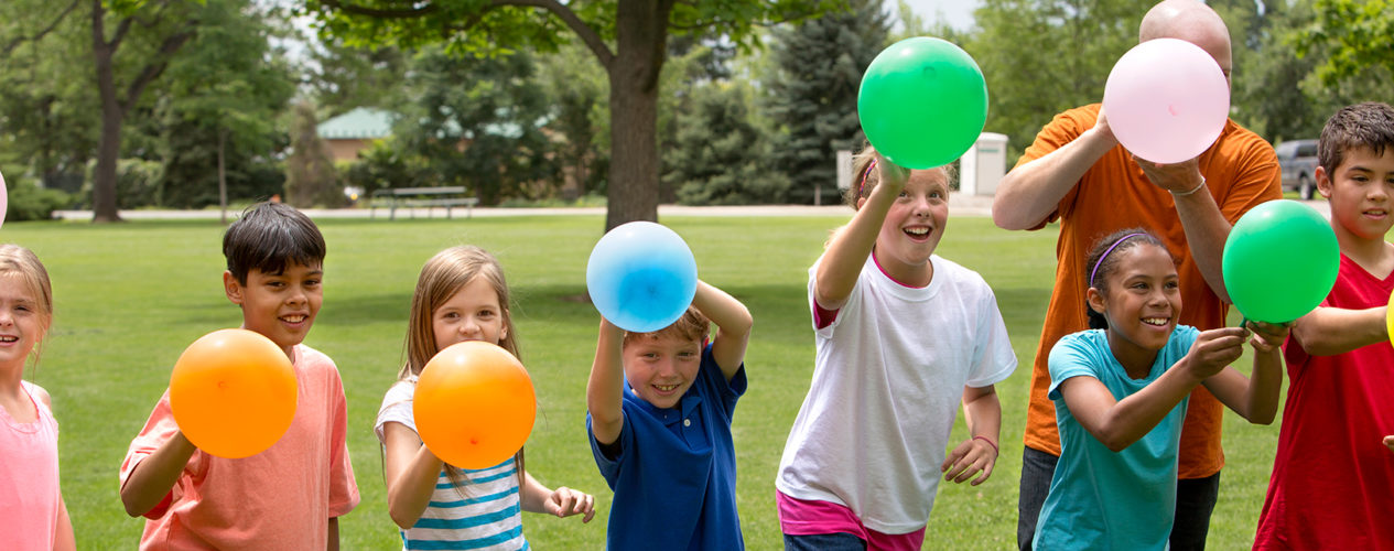 A group of children participating in a peer pressure activity involving balloons.