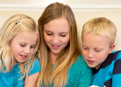 Three kids with different learning styles sitting on a couch together.