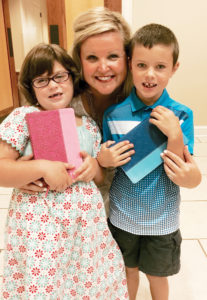 Danielle poses with two first grade students who just received their Bibles.