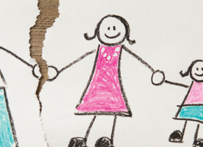 A kid's drawing of a stick figure mom, dad, and daughter, holding hands. The paper is torn between the mom and dad.