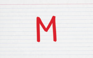 An index card with a capital letter "M" on it.
