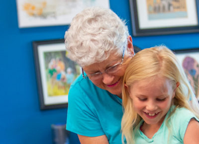 An older woman and a child work together on a cross-generational lesson.