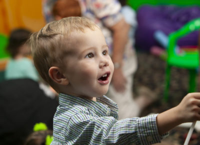 toddler looking in awe as he engages in nursery activity