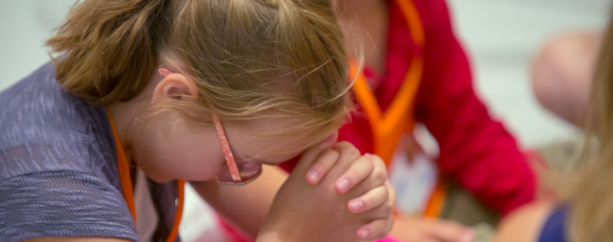 young girl seated in prayer
