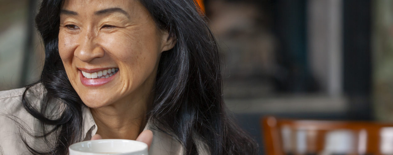 volunteer holding coffee mug and smiling