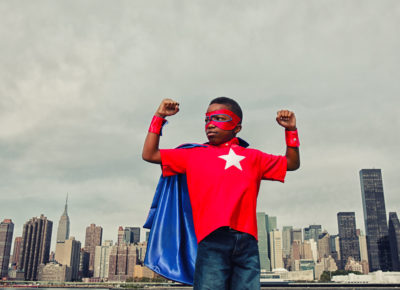 child posing as super hero